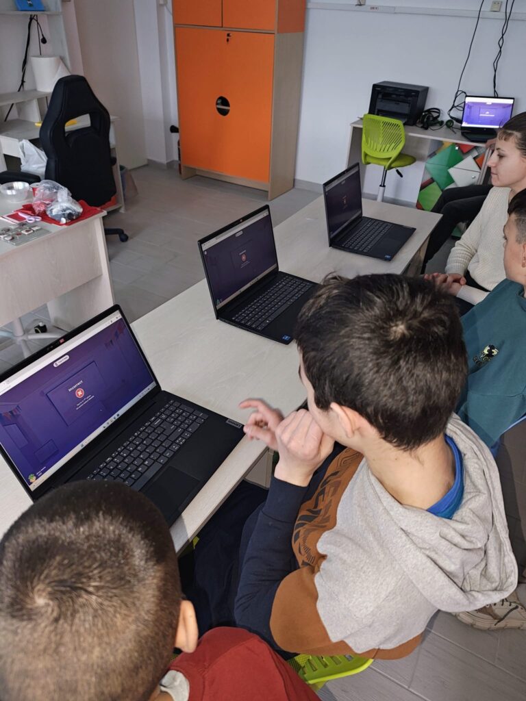 Elevi lucrează la laptop-uri
