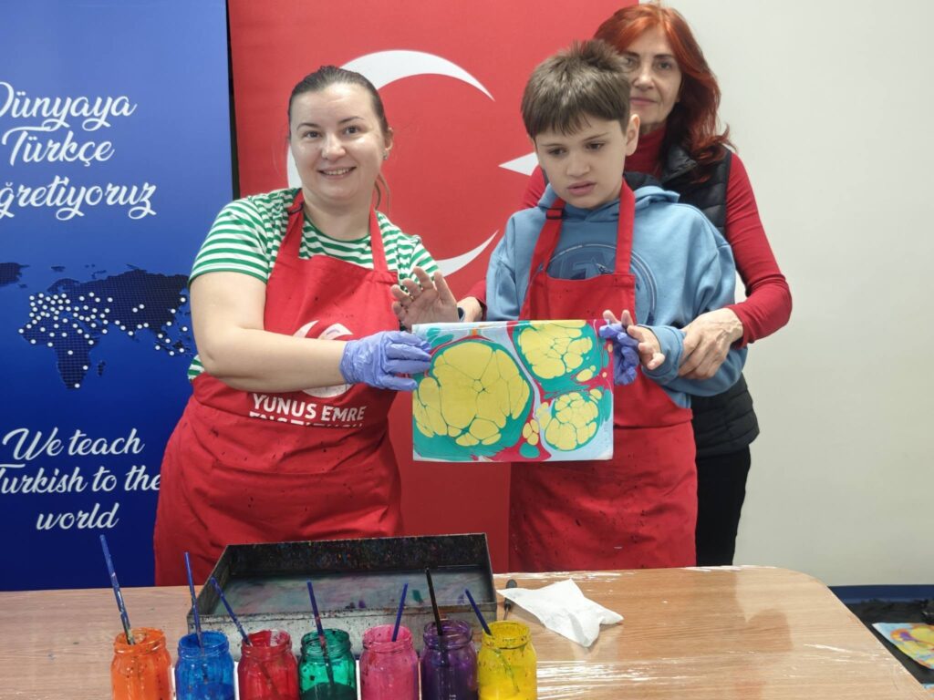 doamnele profesoare și elevul zâmbesc la poză