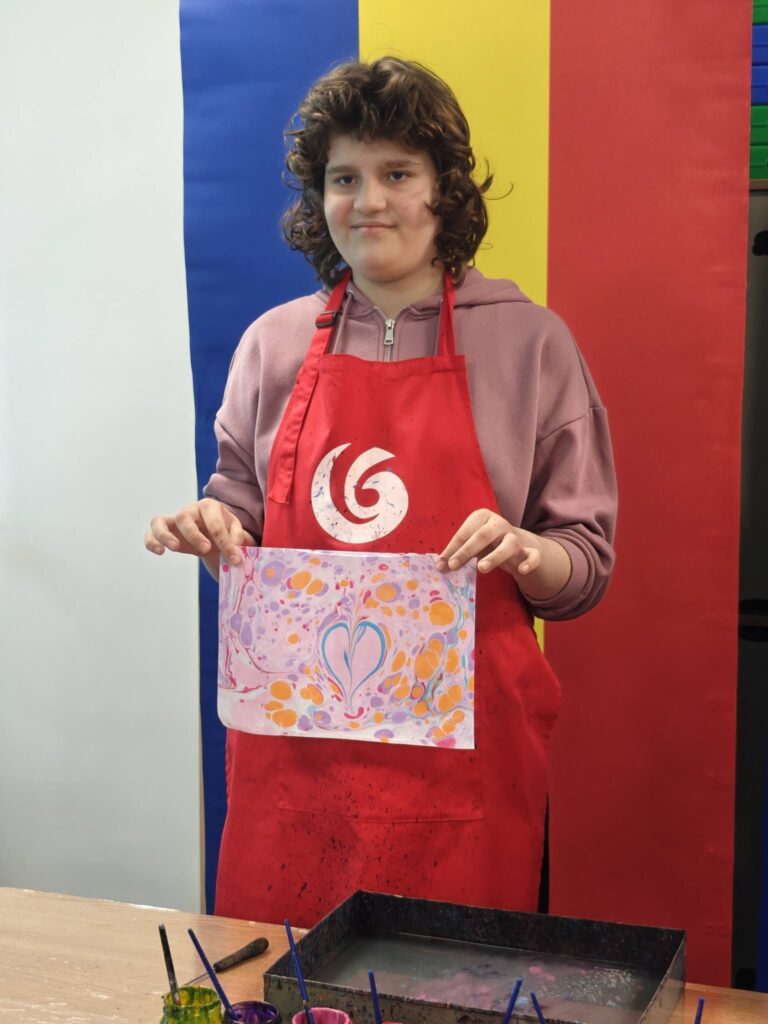 eleva zâmbește și afișează lucrarea cu inimă roz