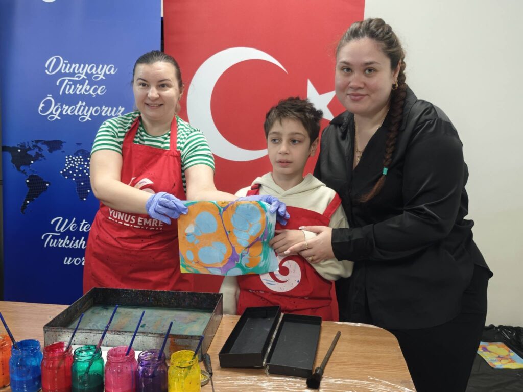 elevul afișează un fluturaș pictat folosind portocaliu și acvamarin