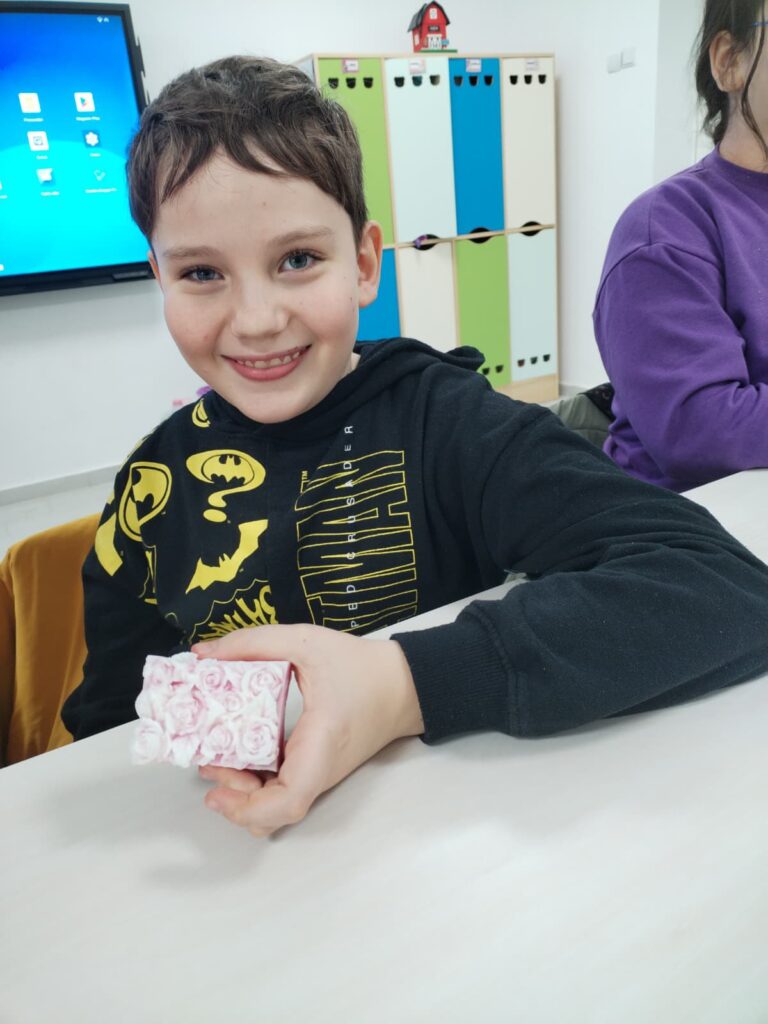 elevul prezintă lumânarea realizată de el, cu model de trandafiri