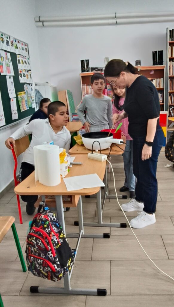 profesoara prezinta elevilor aparatul pentru clătite