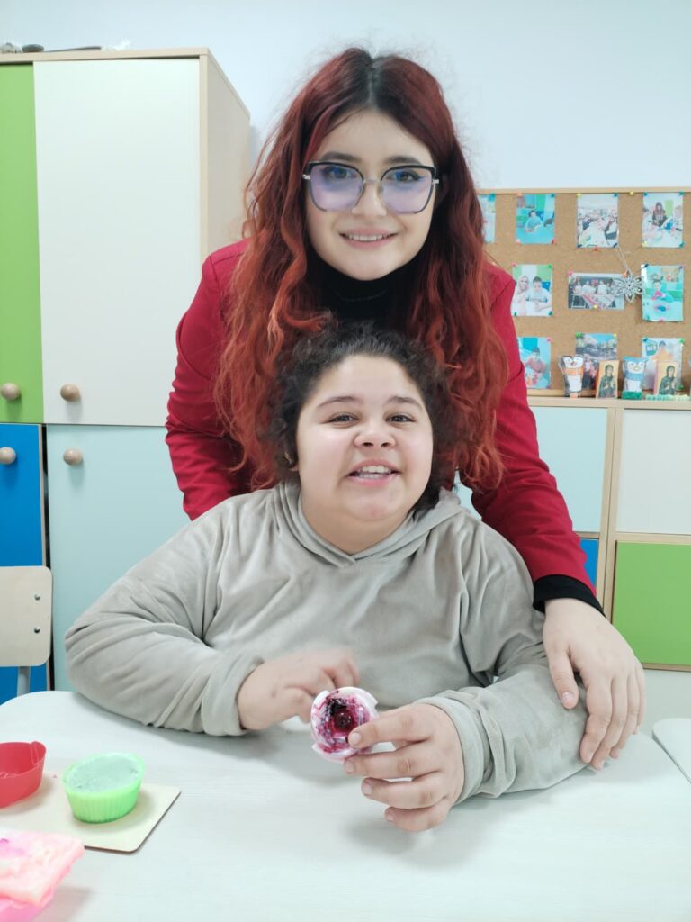 profesoară și eleva care ține un trandafir din ceară