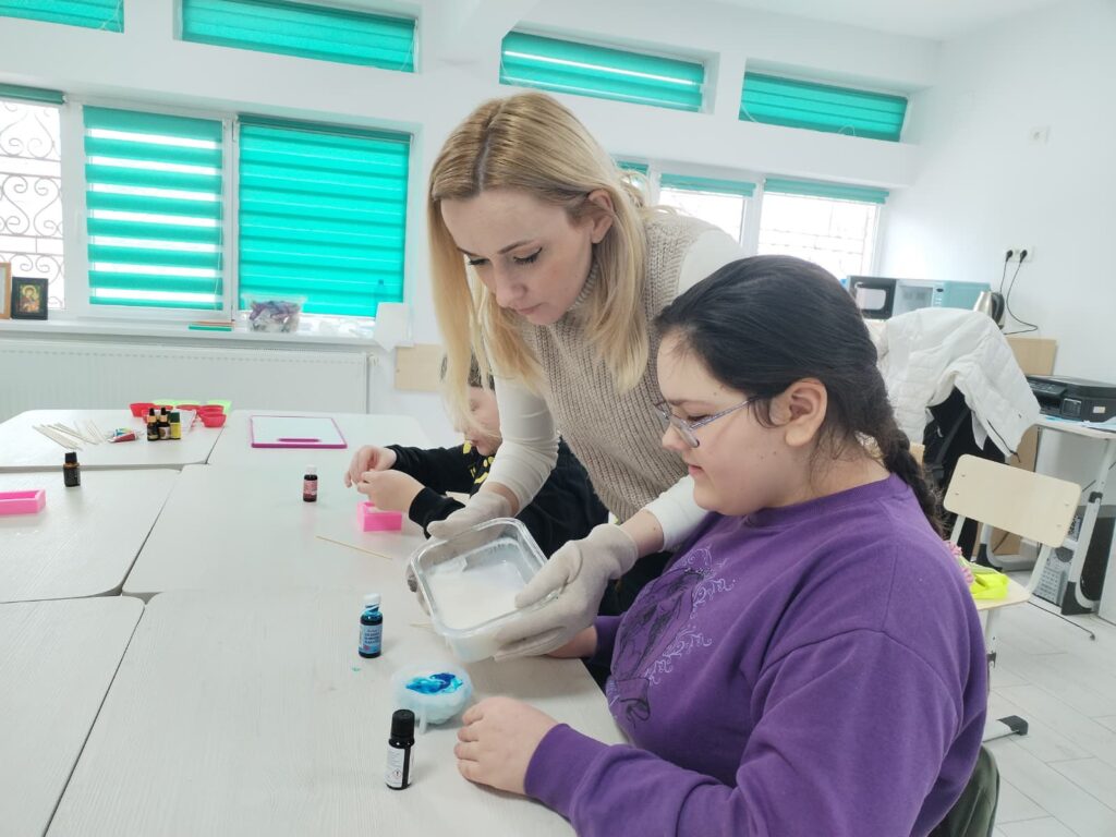 profesoara și eleva toarnă ceară în formă