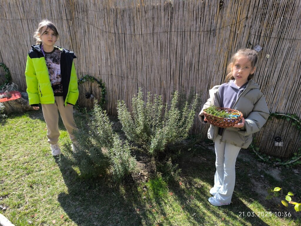 Elevi pozează în grădină alături de plantele adunate