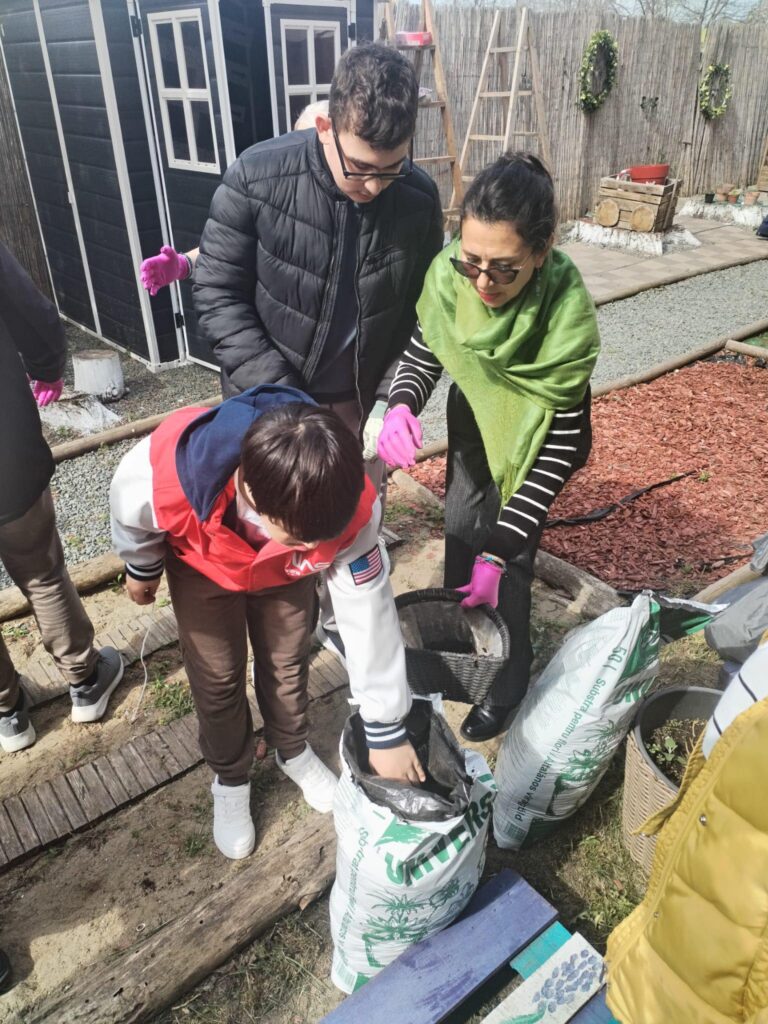 doamna profesoară și elevii desfac sacii cu îngrăsământ