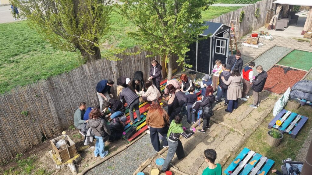 elevi în grădina senzorială plantează flori - poză de sus