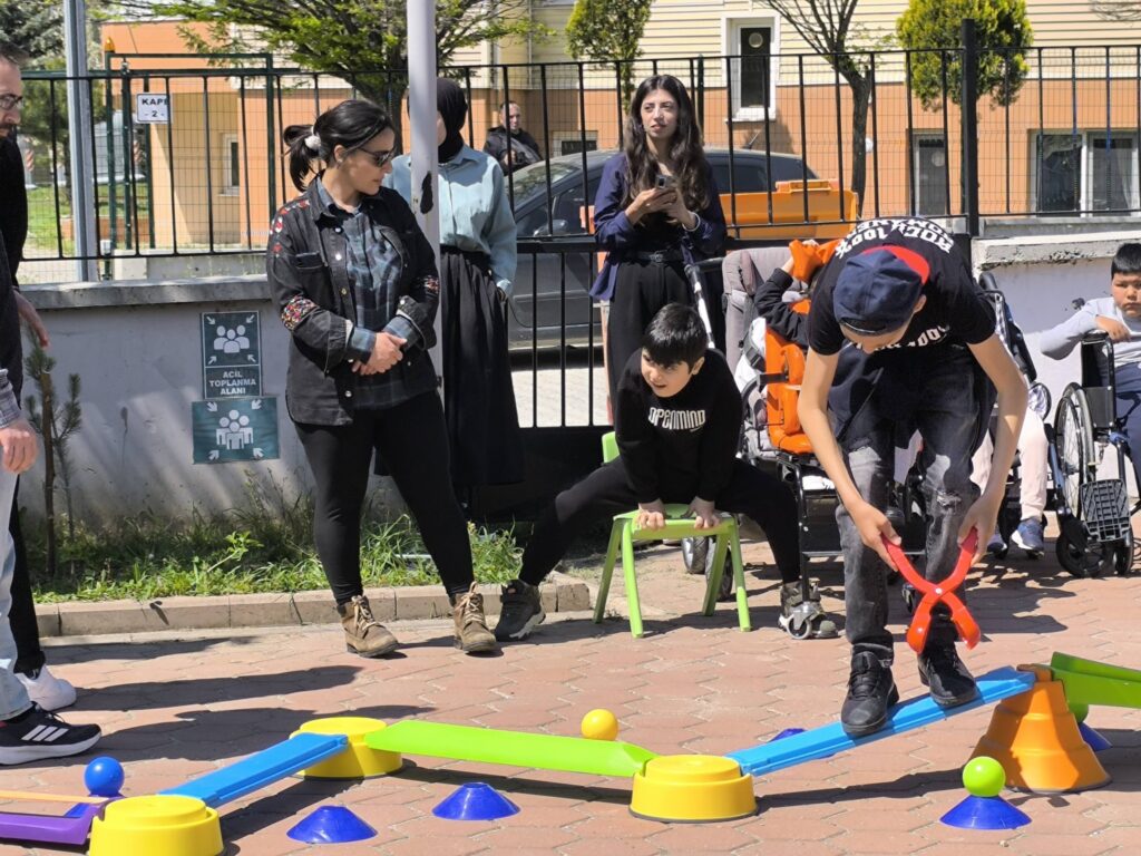 Elevi la ora de educație fizică fac exerciții utilizând echipamente colorate
