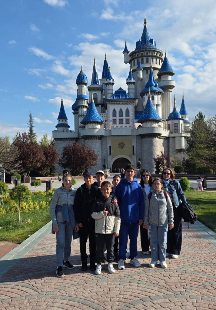 Elevii pozează zâmbind în fața „Castelului din basme” în parcul Sazova