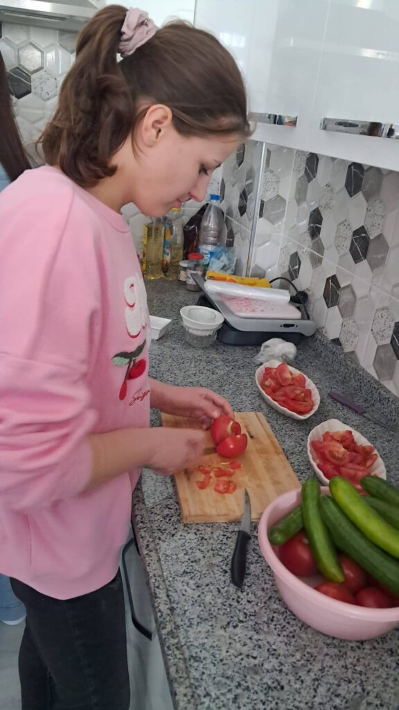 Elevi taie legumele la bucătărie