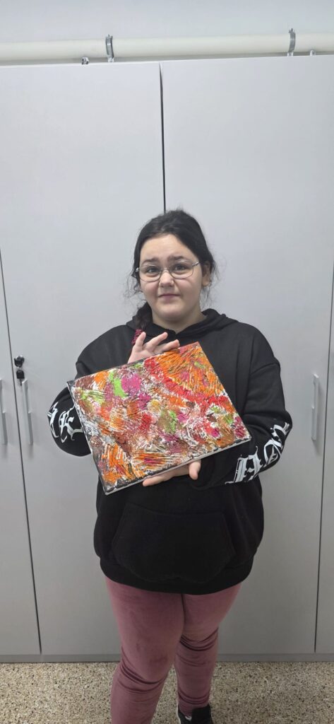 Elevă arată planșa realizată la atelier