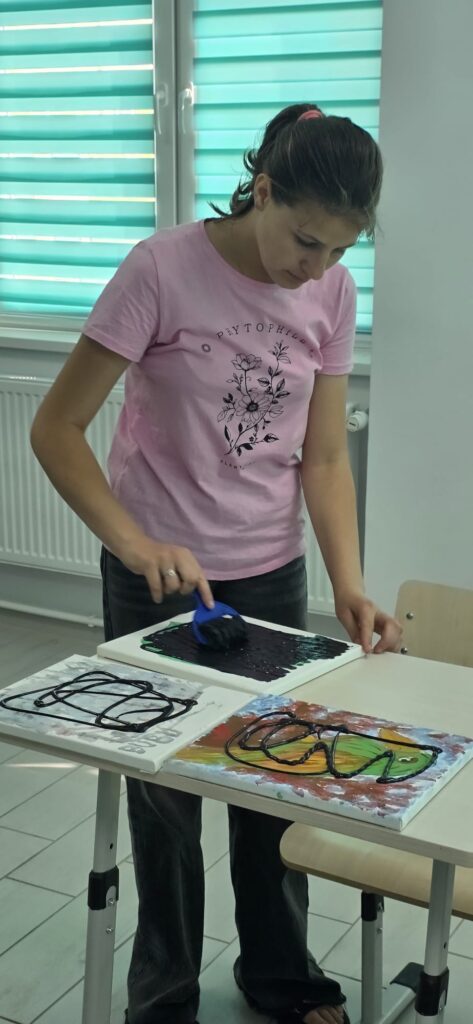 Elevi pictează planșa cu negru
