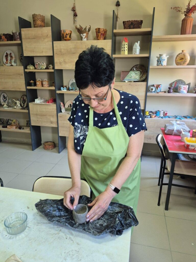 doamna profesoară realizează o cană din lut