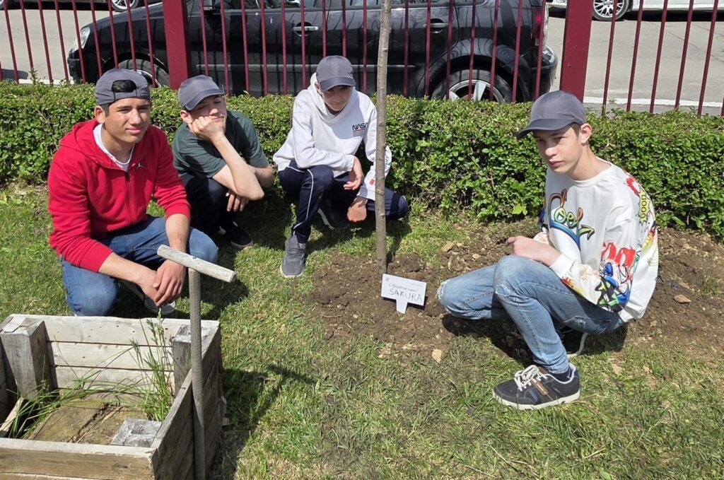 Elevii lângă pomul plantat în curtea mare