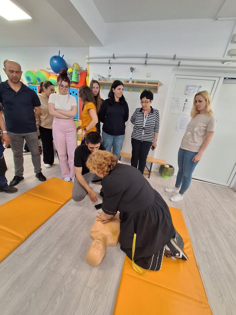 doamna profesoară realizează masaj cardiac pe un manechin