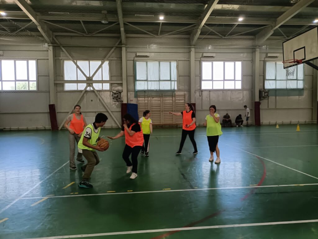 Meciul de baschet în desfășurare la mijlocul terenului