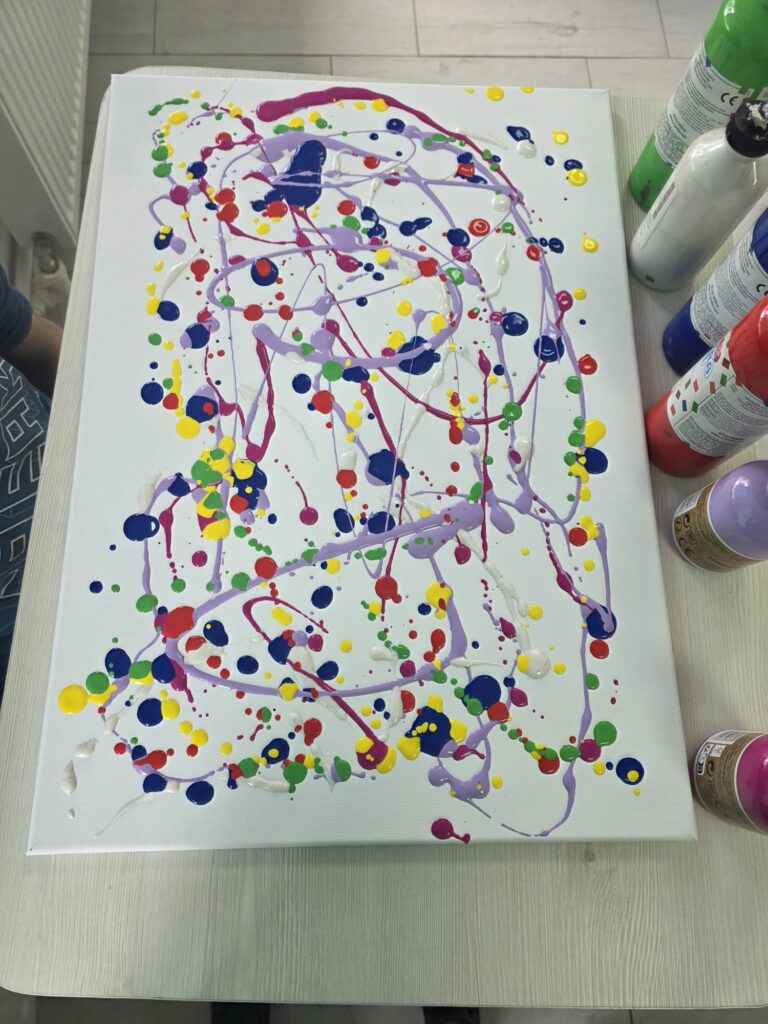 Planși pictată cu puncte și linii colorate: galben, roșu, verde, albastru.