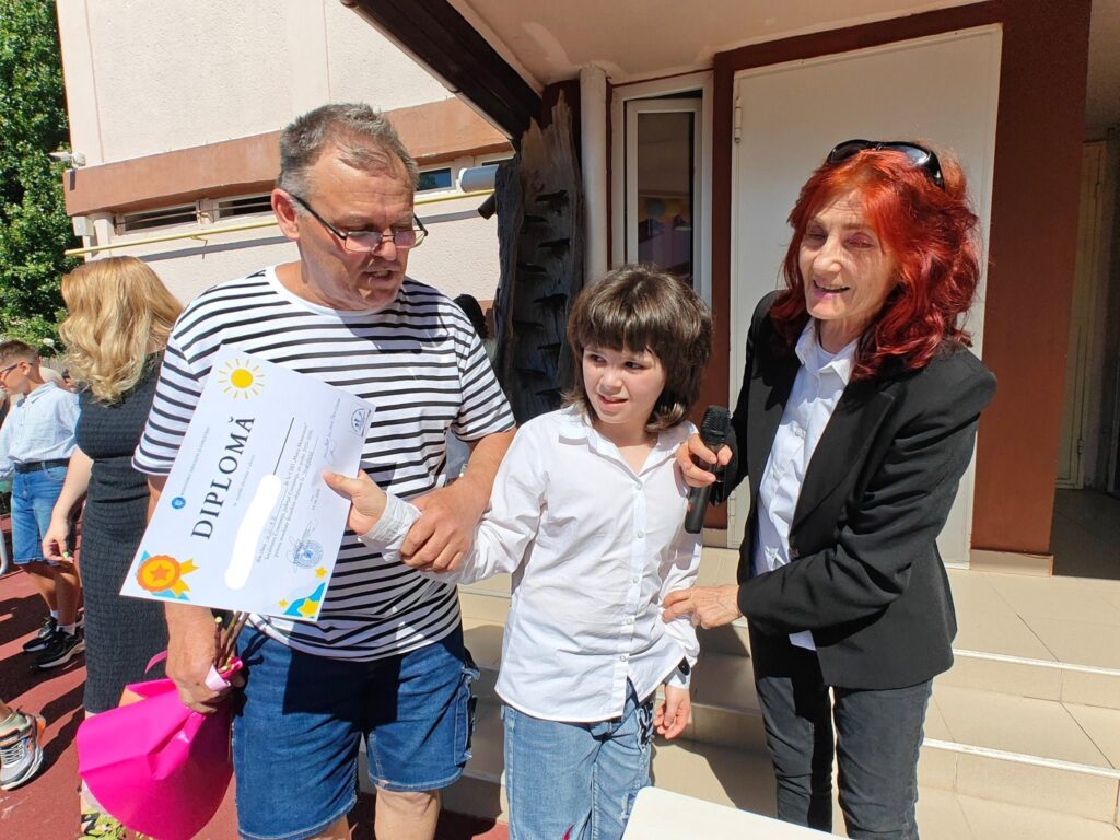 doamna profesoară alătur de un elev și tatăl lui