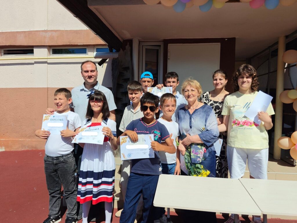elevii alături de doamna dirigintă arată diplomele primite