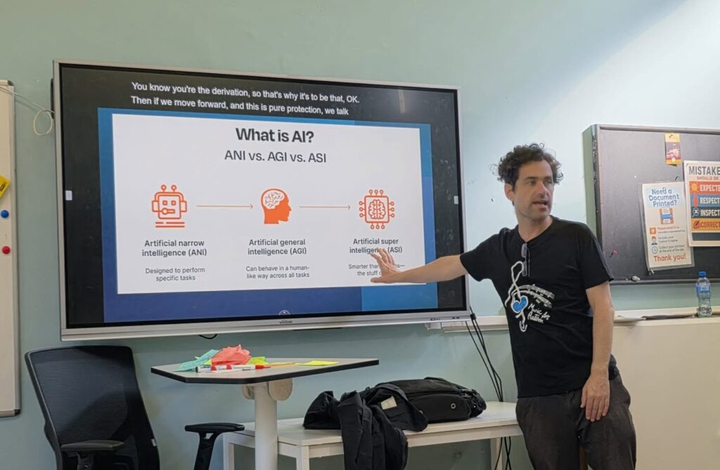 Formatorul prezintă diapozitivul „What is AI? ANI vs. AGI vs. ASI”, care explică tipurile de inteligență artificială.