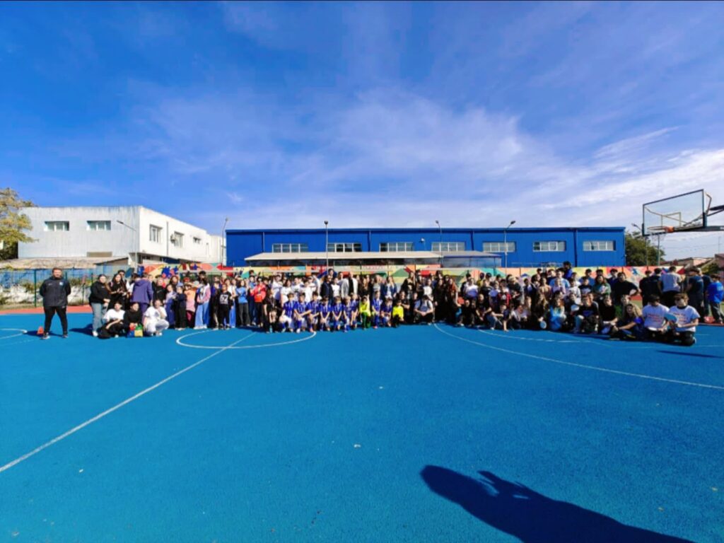 Fotografie de grup panoramică cu toți participanții la Sport Fest 2026, ediția a II-a, pe terenul de sport albastru.