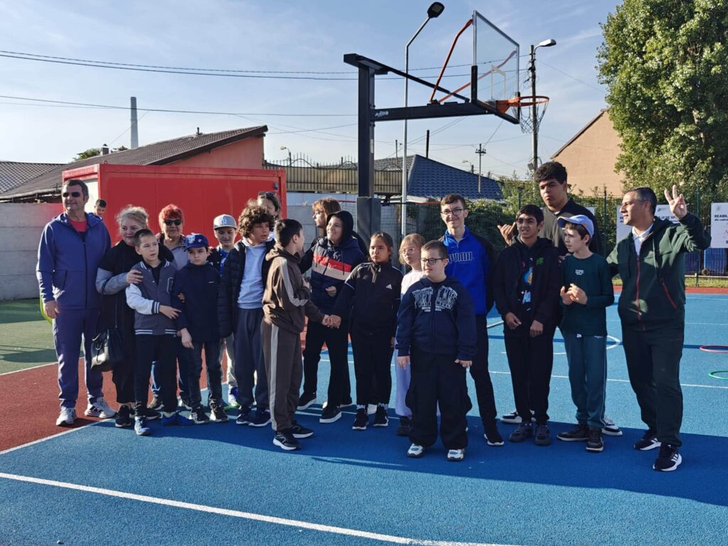 Grup de elevi și profesori zâmbind lângă coșul de baschet, la Sport Fest 2026.