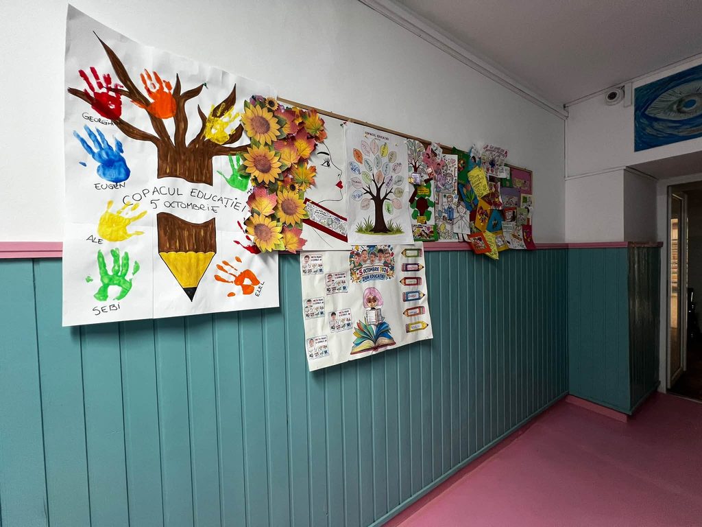 Vizualizare panoramică a unui perete  decorat cu diverse proiecte artistice și postere dedicate evenimentului „Ziua Educației”